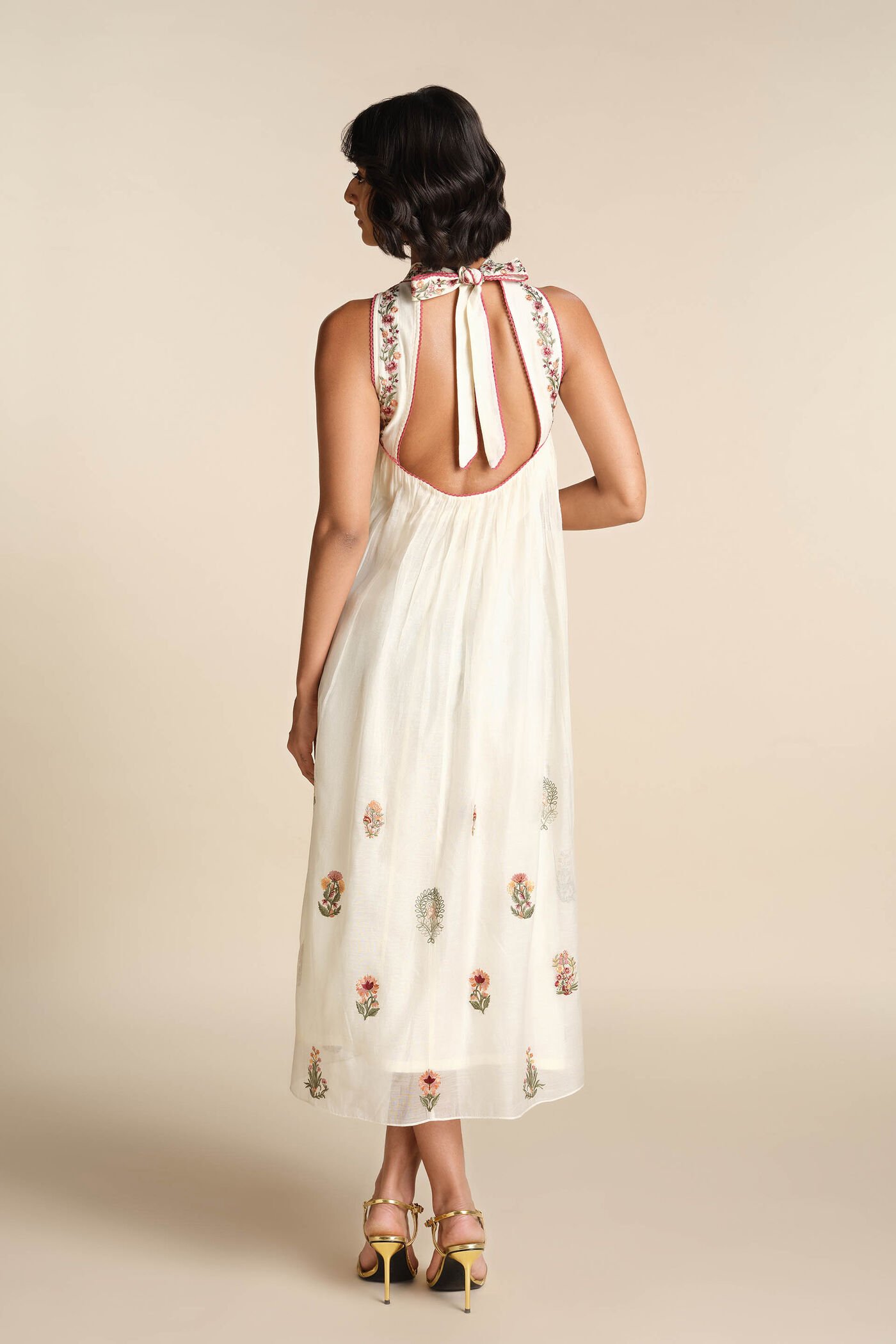 Ivory sleeveless embroidered midi dress with floral motifs and high neckline, elegant festive wear for women