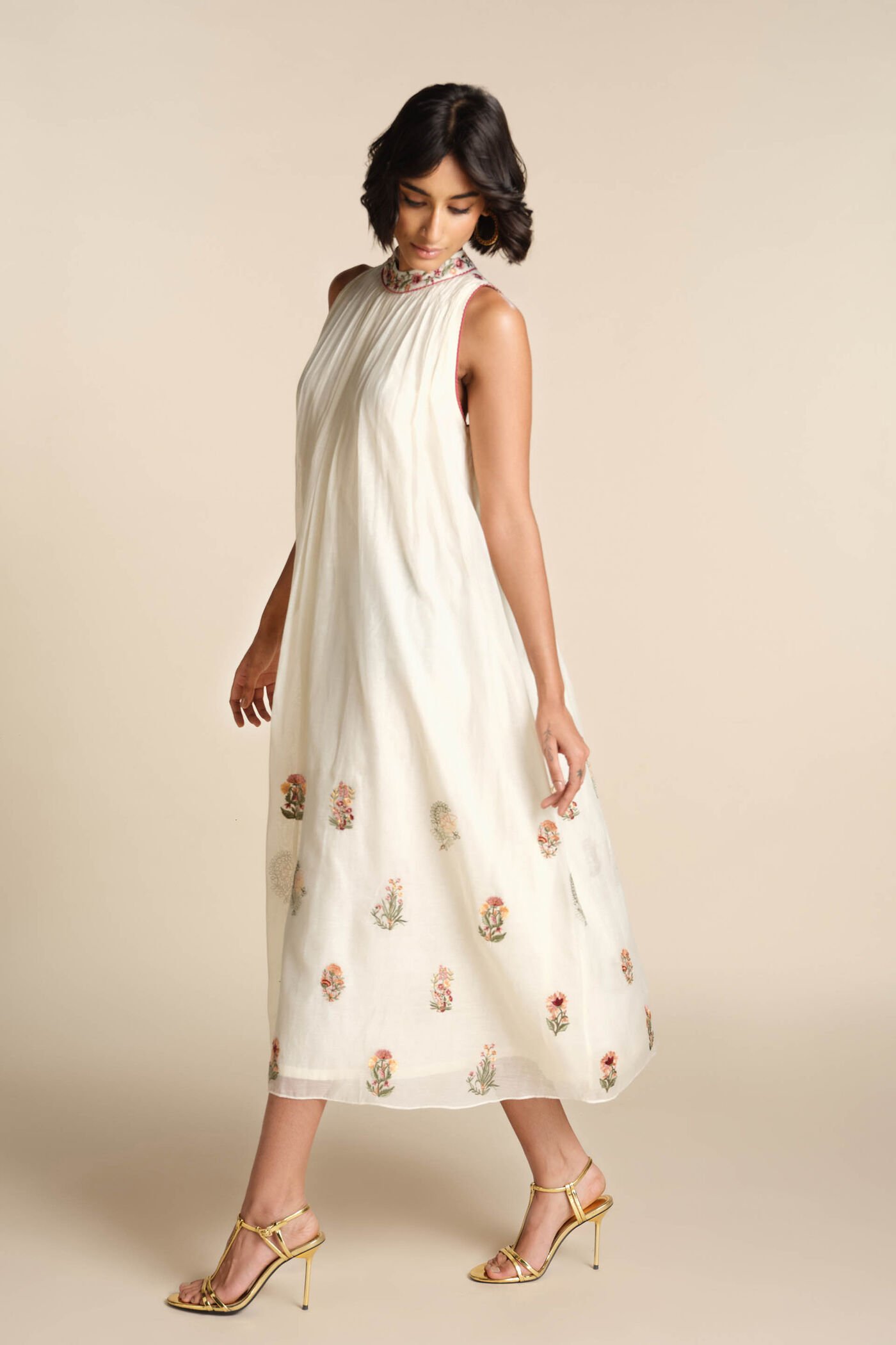 Ivory sleeveless embroidered midi dress with floral motifs and high neckline, elegant festive wear for women