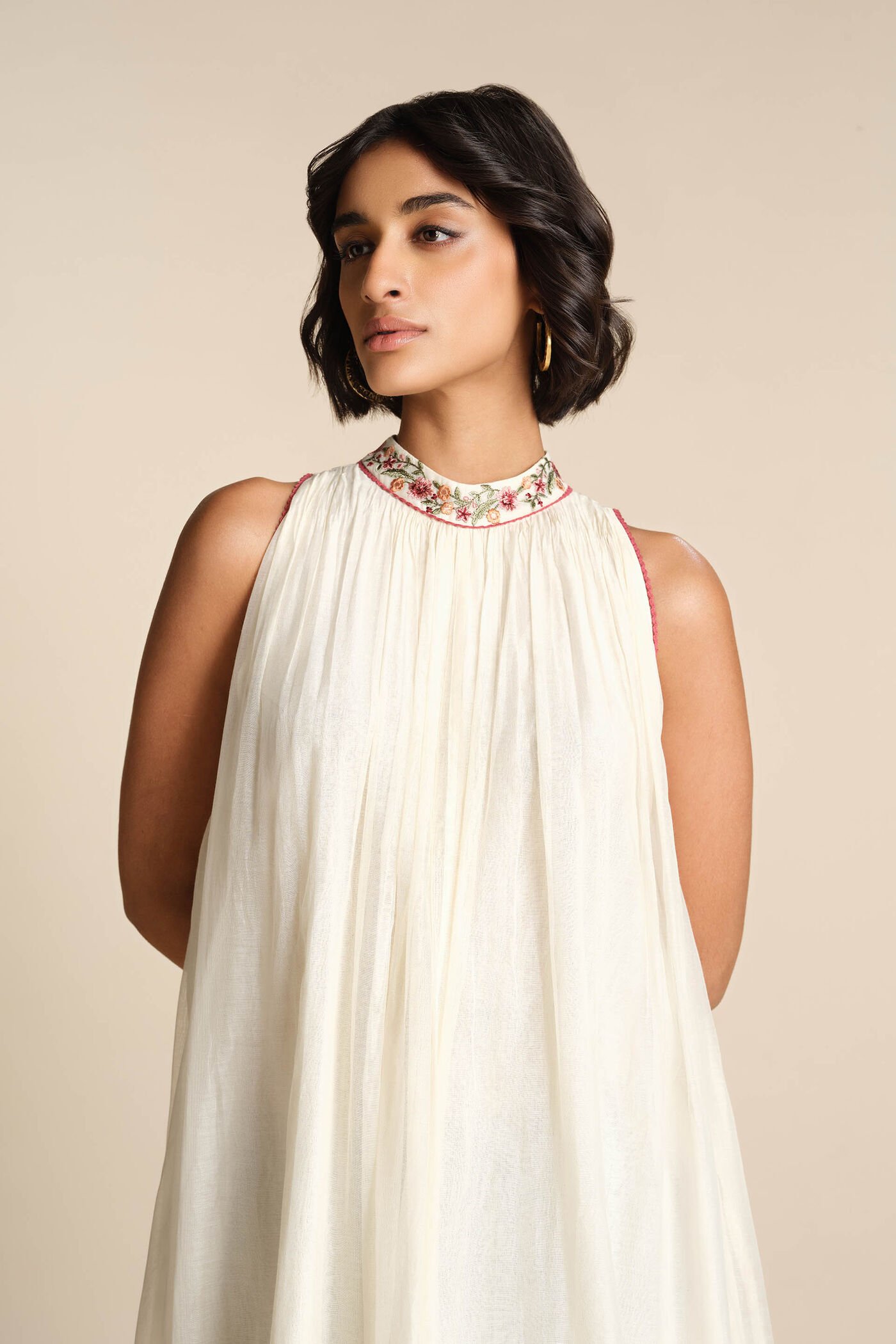 Ivory sleeveless embroidered midi dress with floral motifs and high neckline, elegant festive wear for women