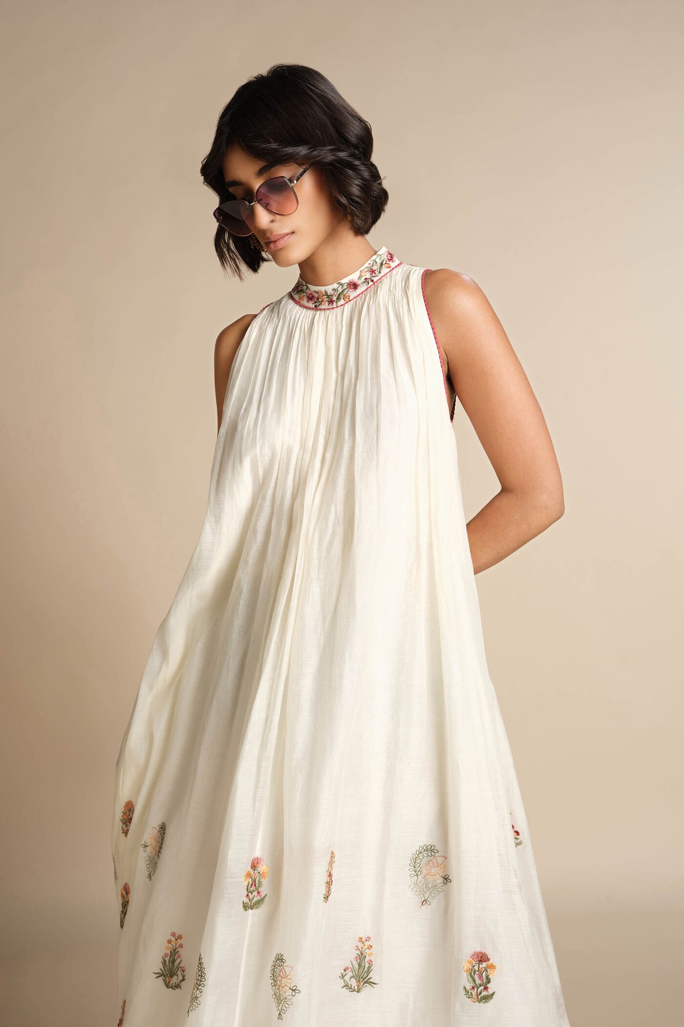 Ivory sleeveless embroidered midi dress with floral motifs and high neckline, elegant festive wear for women