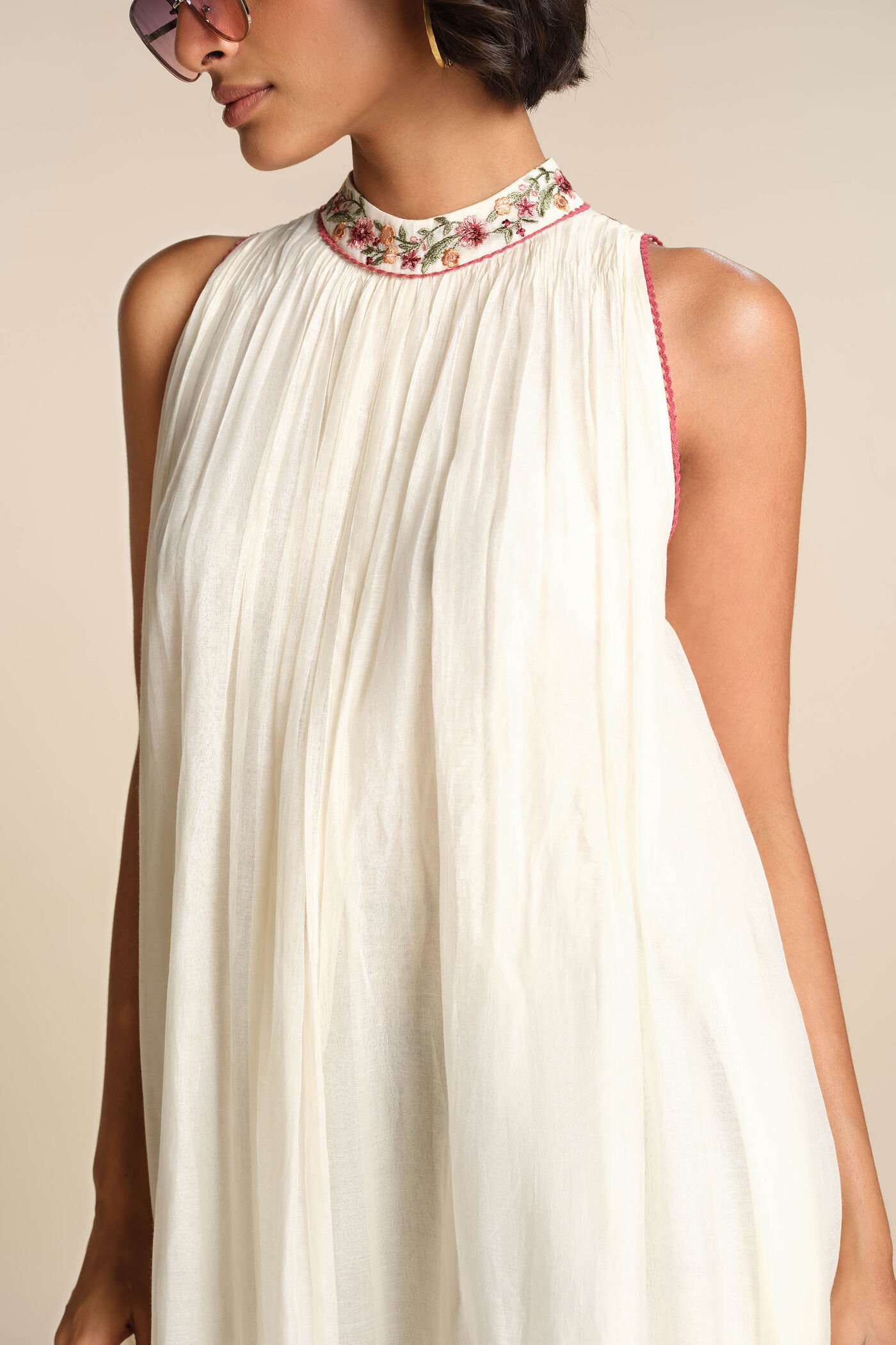 Ivory sleeveless embroidered midi dress with floral motifs and high neckline, elegant festive wear for women