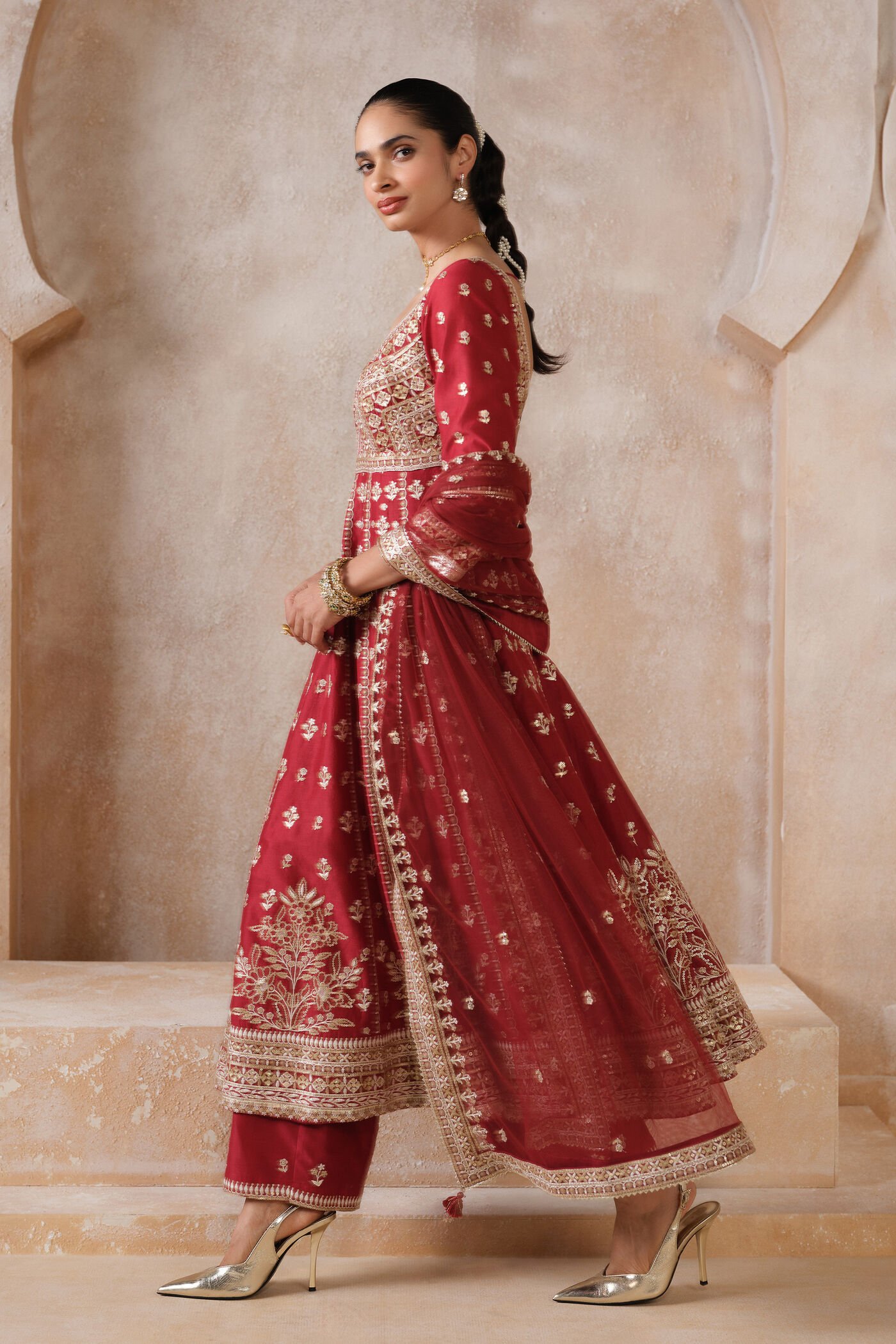 Traditional red Anarkali suit with heavy gold embroidery and matching dupatta for bridal and festive wear.